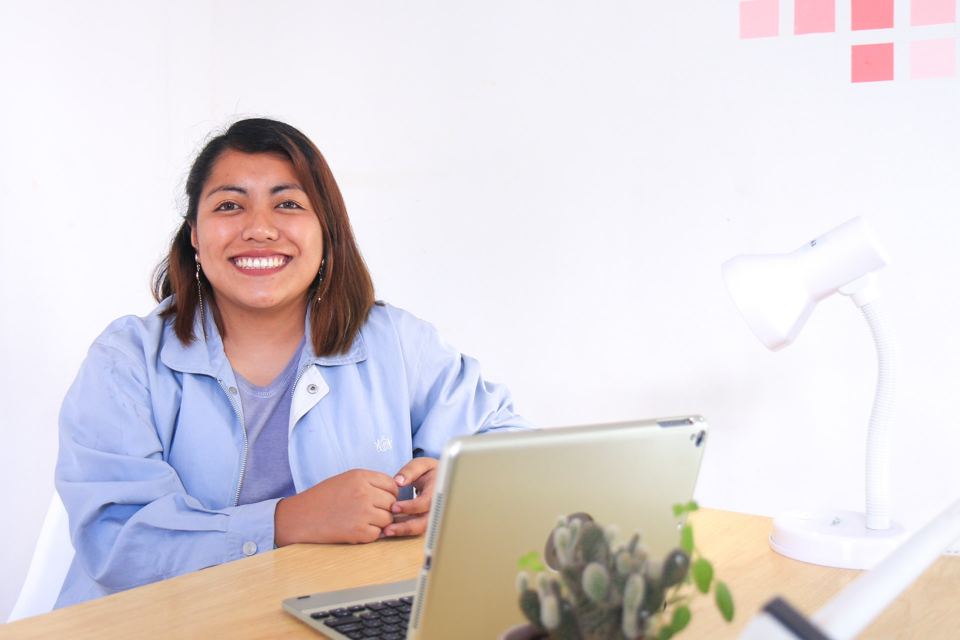 teacher smiling in front of laptop